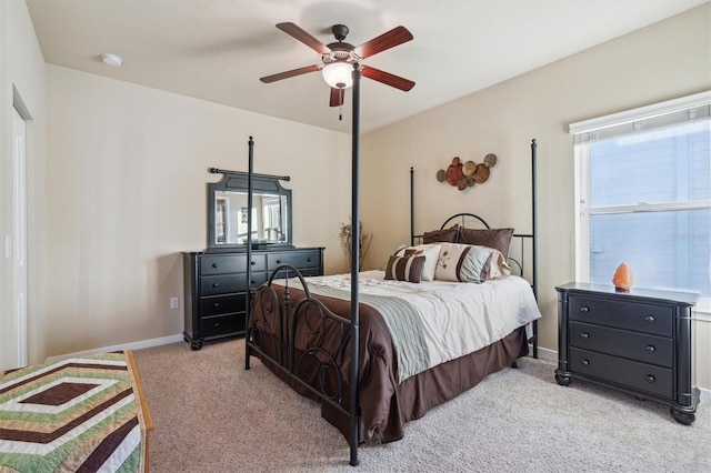 bedroom with light carpet, ceiling fan, and baseboards