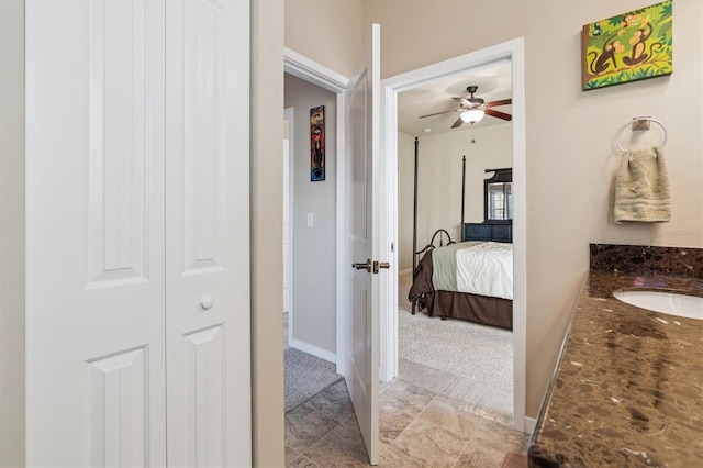 ensuite bathroom featuring a ceiling fan, vanity, baseboards, and ensuite bathroom