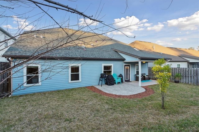 back of house featuring a yard, a patio, fence, and roof with shingles