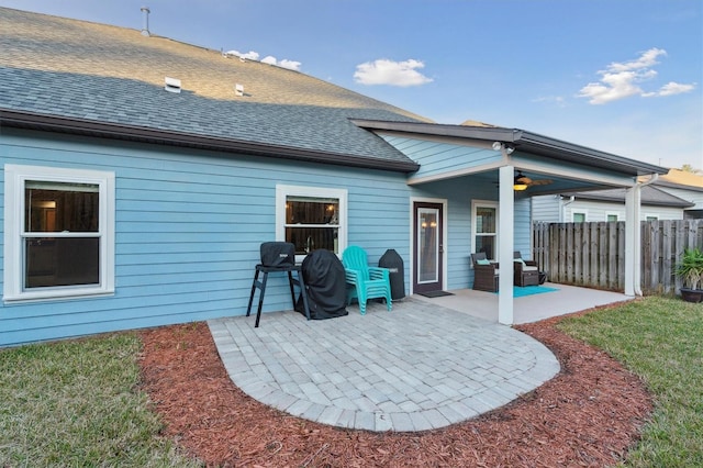 rear view of house with ceiling fan, a patio, roof with shingles, and fence