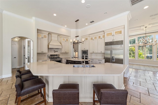 kitchen featuring premium range hood, built in appliances, a large island, and a kitchen bar