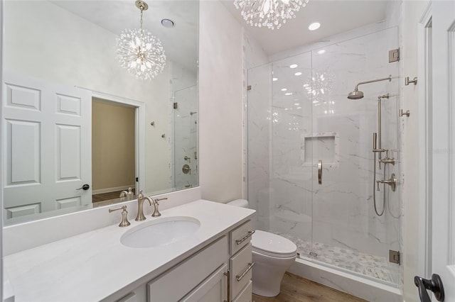 bathroom featuring walk in shower, vanity, wood-type flooring, a chandelier, and toilet