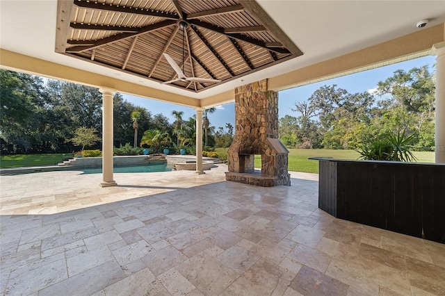 view of patio featuring an outdoor stone fireplace and a gazebo