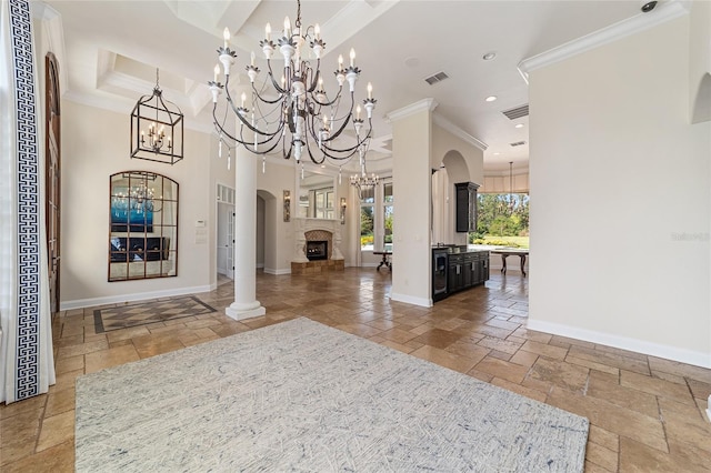 foyer entrance with decorative columns and ornamental molding