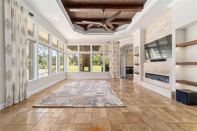 unfurnished sunroom with beam ceiling, ceiling fan, a high end fireplace, and wooden ceiling