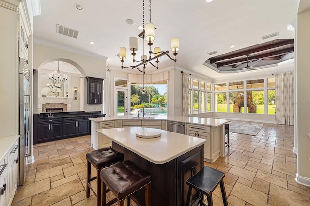 kitchen featuring a center island, a kitchen bar, a healthy amount of sunlight, and crown molding