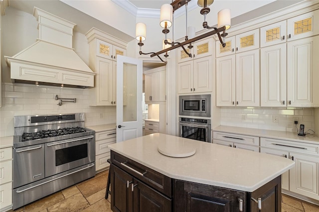 kitchen with ornamental molding, premium range hood, appliances with stainless steel finishes, and tasteful backsplash