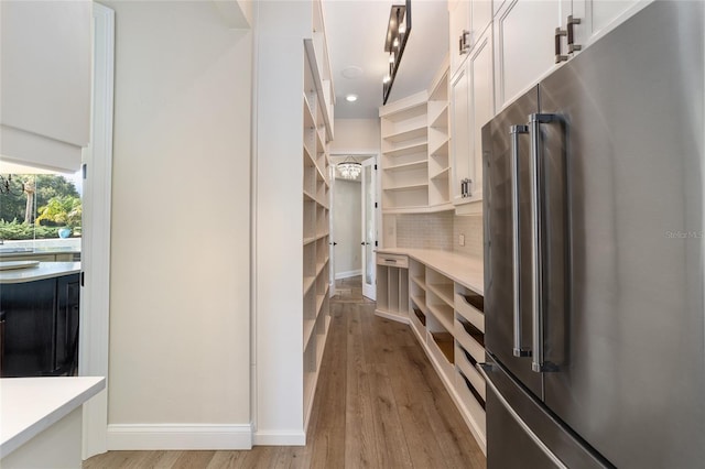 walk in closet with light hardwood / wood-style floors