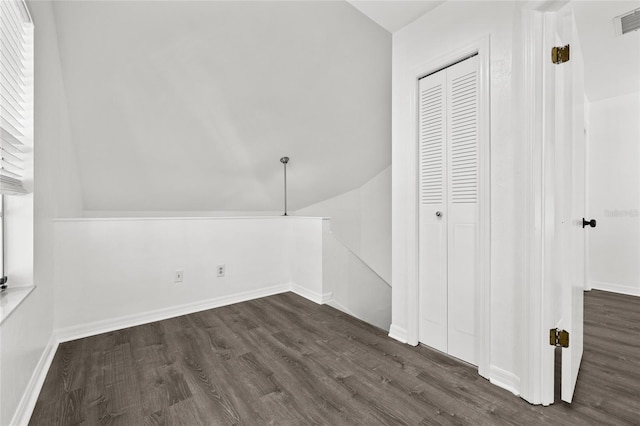 additional living space with dark hardwood / wood-style floors and vaulted ceiling