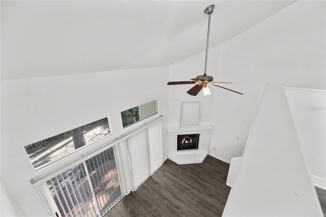 unfurnished living room with a fireplace, dark hardwood / wood-style flooring, high vaulted ceiling, and ceiling fan