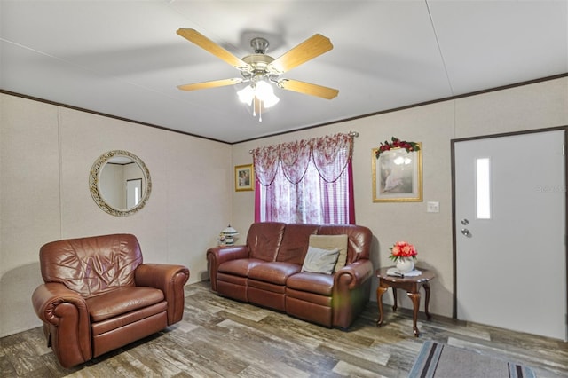 living room with hardwood / wood-style floors, ceiling fan, and ornamental molding