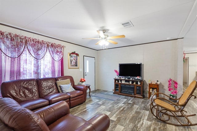 living room with a fireplace, hardwood / wood-style flooring, ceiling fan, and crown molding