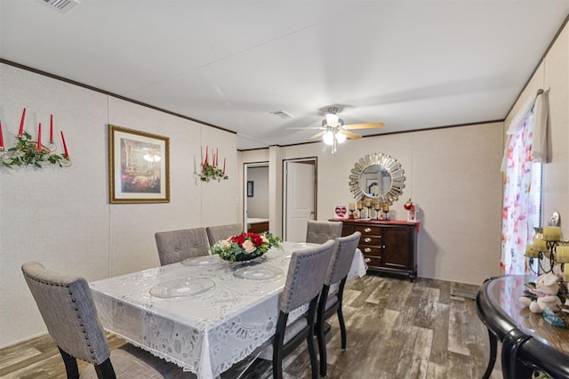 dining area with crown molding, ceiling fan, and dark wood-type flooring