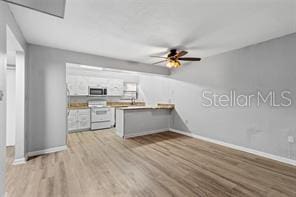 kitchen featuring white cabinets, light hardwood / wood-style flooring, ceiling fan, white range oven, and kitchen peninsula