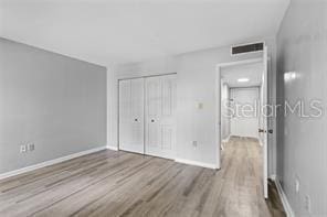 unfurnished bedroom featuring light hardwood / wood-style floors and a closet