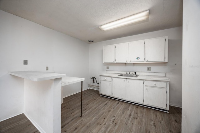 kitchen with white cabinetry, sink, kitchen peninsula, a kitchen bar, and light wood-type flooring