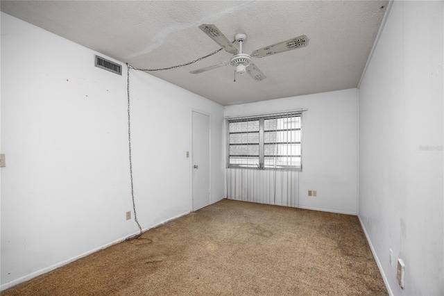 carpeted empty room featuring a textured ceiling and ceiling fan