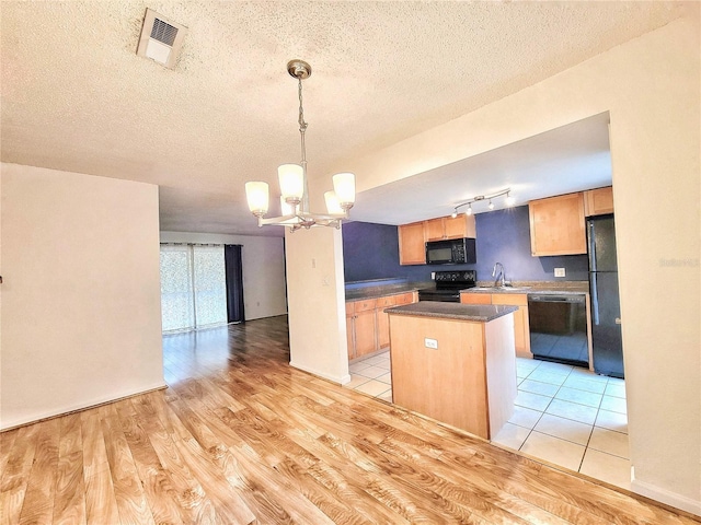 kitchen with light wood-type flooring, black appliances, pendant lighting, a chandelier, and a kitchen island