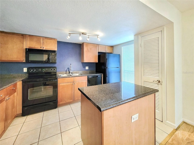 kitchen with sink, a center island, a textured ceiling, light tile patterned floors, and black appliances