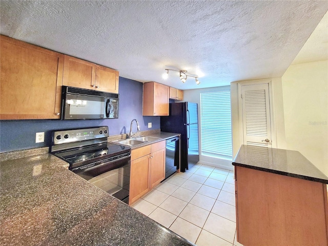 kitchen with black appliances, sink, light tile patterned floors, and a textured ceiling