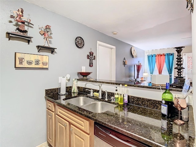 kitchen featuring light brown cabinetry, dishwasher, sink, and dark stone counters