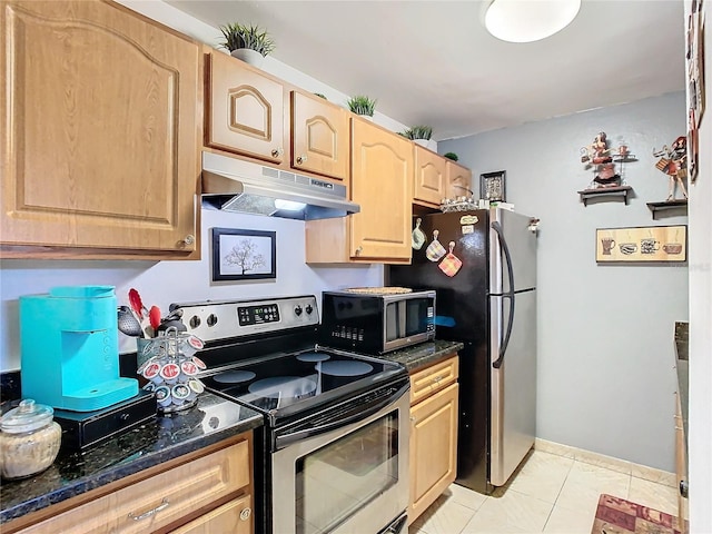 kitchen featuring appliances with stainless steel finishes, light tile patterned floors, light brown cabinetry, and dark stone countertops