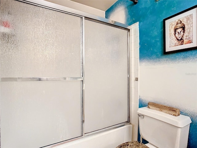 bathroom with shower / bath combination with glass door and toilet