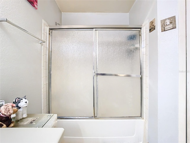 bathroom with combined bath / shower with glass door