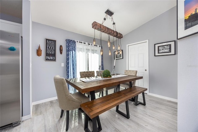 dining space with lofted ceiling and light wood-type flooring