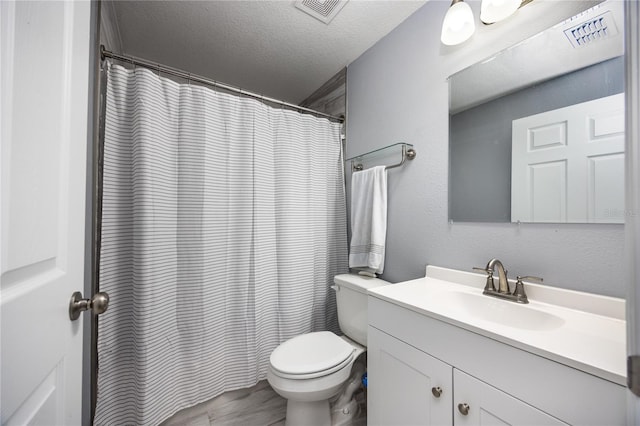 bathroom featuring vanity, a textured ceiling, and toilet