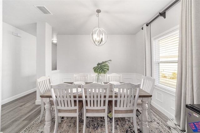 dining room featuring wood-type flooring and an inviting chandelier