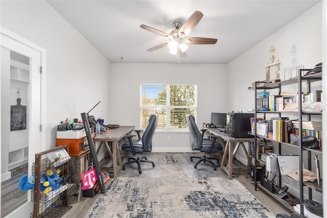 office with light hardwood / wood-style floors and ceiling fan