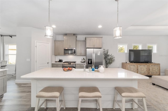 kitchen with a breakfast bar area, pendant lighting, and appliances with stainless steel finishes