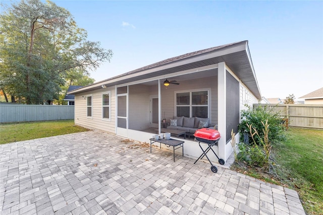 back of property featuring a lawn, ceiling fan, a patio area, and an outdoor hangout area