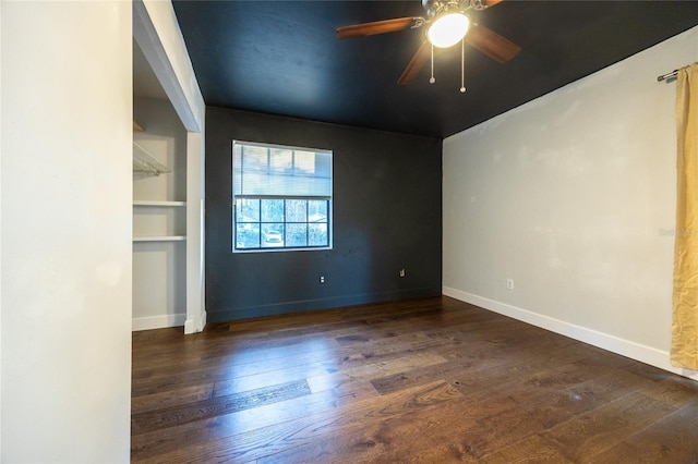 spare room featuring ceiling fan, dark hardwood / wood-style flooring, and built in features