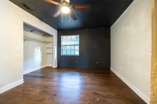 unfurnished bedroom featuring a closet, dark hardwood / wood-style floors, and ceiling fan