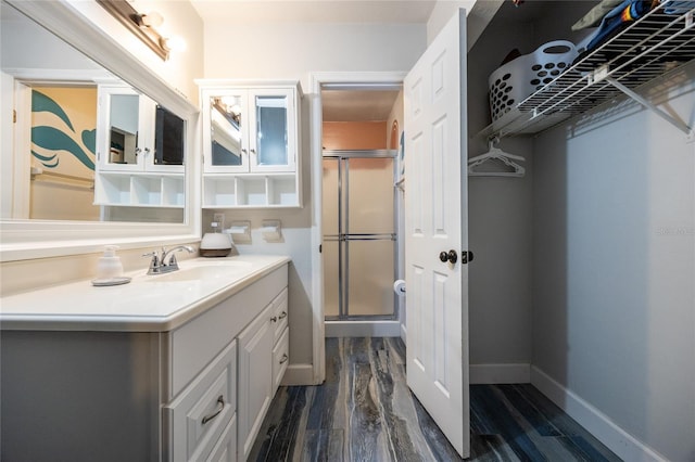 bathroom featuring walk in shower, vanity, and hardwood / wood-style flooring