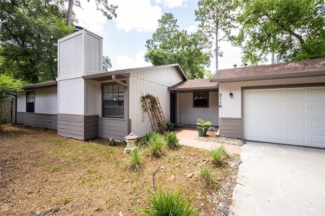 2116 SW 73rd St, Gainesville, FL 32607 - view of front of home with an attached garage, a chimney, concrete driveway, and a shingled roof