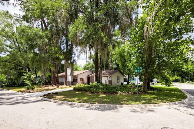 2116 SW 73rd St, Gainesville, FL 32607 - view of front of property featuring a front lawn, view of wooded area, driveway, and an attached garage