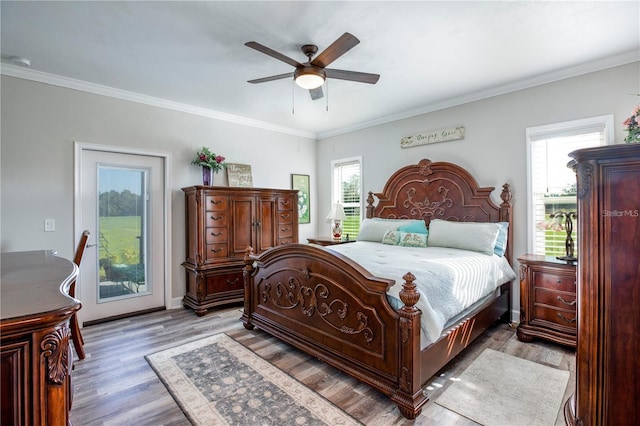 bedroom with multiple windows, ceiling fan, crown molding, and wood-type flooring