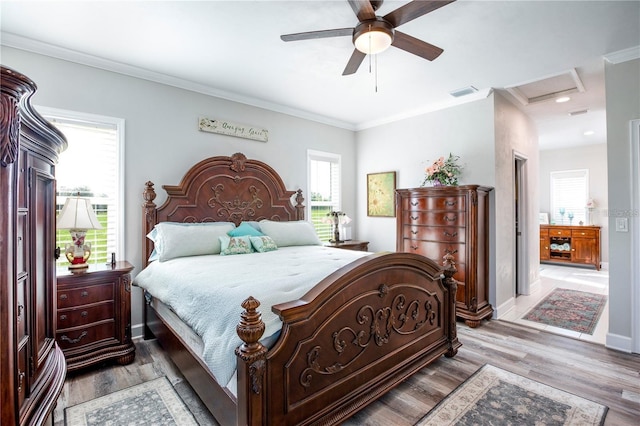 bedroom featuring hardwood / wood-style flooring, ceiling fan, and crown molding