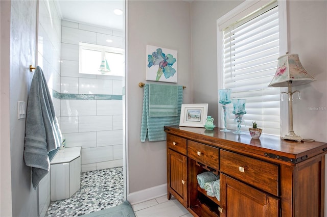 bathroom featuring tiled shower, tile patterned floors, and a healthy amount of sunlight