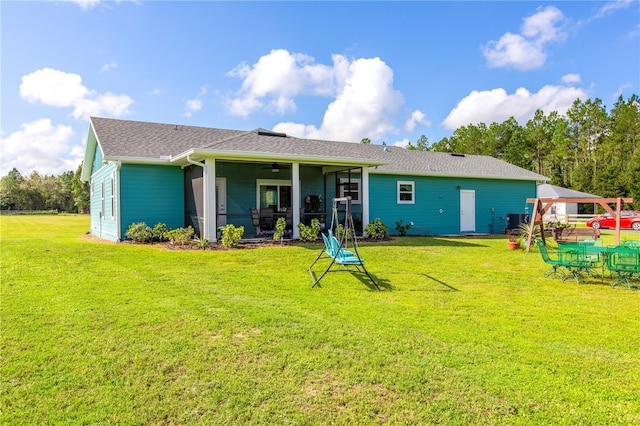 rear view of property with ceiling fan, a sunroom, cooling unit, and a lawn