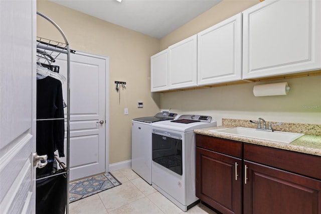 washroom with cabinets, light tile patterned floors, sink, and washing machine and clothes dryer