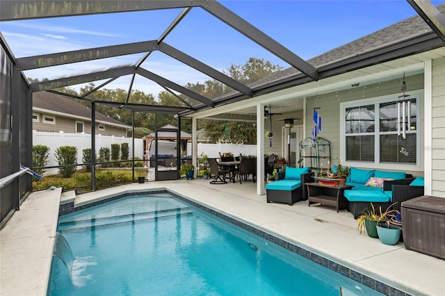 view of pool featuring outdoor lounge area, ceiling fan, a lanai, pool water feature, and a patio area