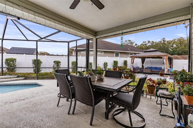 view of patio featuring a gazebo, ceiling fan, a fenced in pool, and a lanai