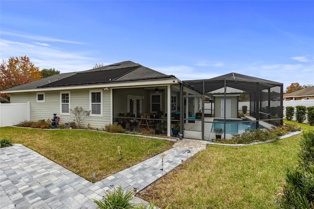 back of house featuring a lanai, a fenced in pool, and a yard