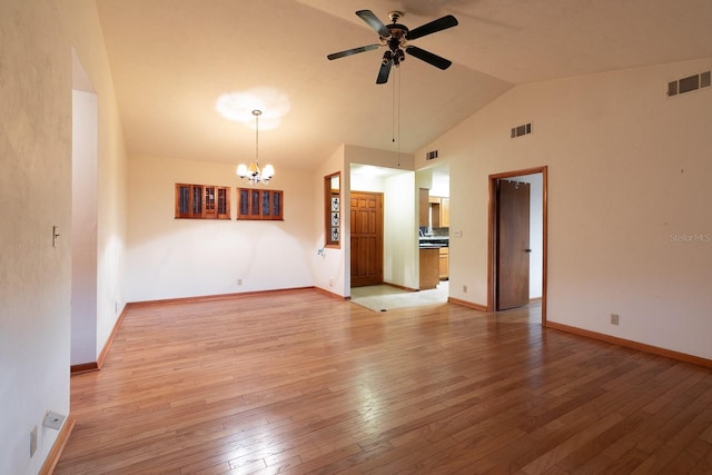 unfurnished living room with ceiling fan with notable chandelier, light hardwood / wood-style floors, and vaulted ceiling