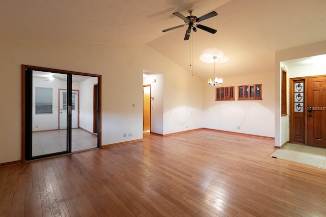 unfurnished living room with vaulted ceiling, ceiling fan with notable chandelier, and light wood-type flooring