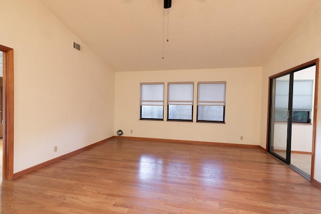 empty room with ceiling fan, light hardwood / wood-style floors, and lofted ceiling